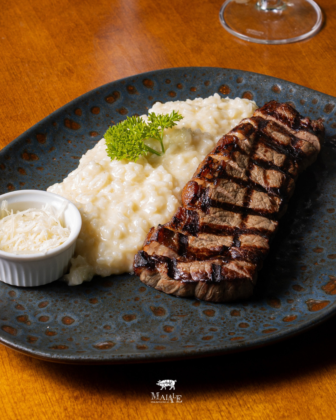 Picanha Estância 92 servida à mesa, com taça de vinho ao fundo.